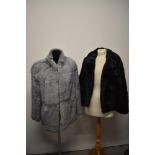 Two rabbit fur coats, one grey and the other black.