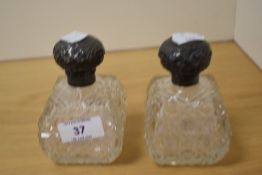 A pair of Edwardian cut glass scent bottles, having Walker & Hall silver lids hallmarked for