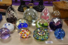 Twelve assorted paperweights including Caithness, Moon Crystal and Strathearn.