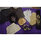 A selection of vintage evening bags, two 1960s tank tops, two pairs of gloves and two belts.