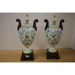 A pair of Victorian enamelled opaline glass vases, of aesthetic design, raised on stepped ebonised