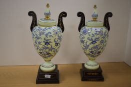 A pair of Victorian enamelled opaline glass vases, of aesthetic design, raised on stepped ebonised
