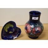 A William Moorcroft pottery vase, tube lined and in the Anemone pattern on blue ground, measuring