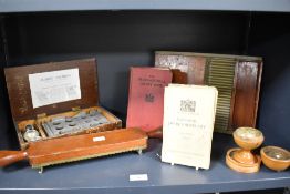 A selection of vintage pharmaceutical items, including pill roller and closing machine, books, and