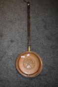 A copper and brass bedpan having rose design to the lid.