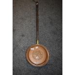 A copper and brass bedpan having rose design to the lid.