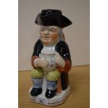 A Victorian Staffordshire Toby jug or pitcher, with stopper, measuring 24cm tall