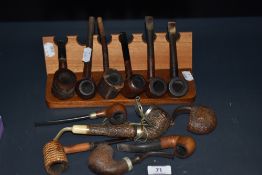 A collection of novelty smoking pipes and stand