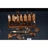 A collection of novelty smoking pipes and stand