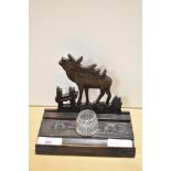 A carved treen ink well/pen stand of primitive form, bearing inscription, having Moose decoration to
