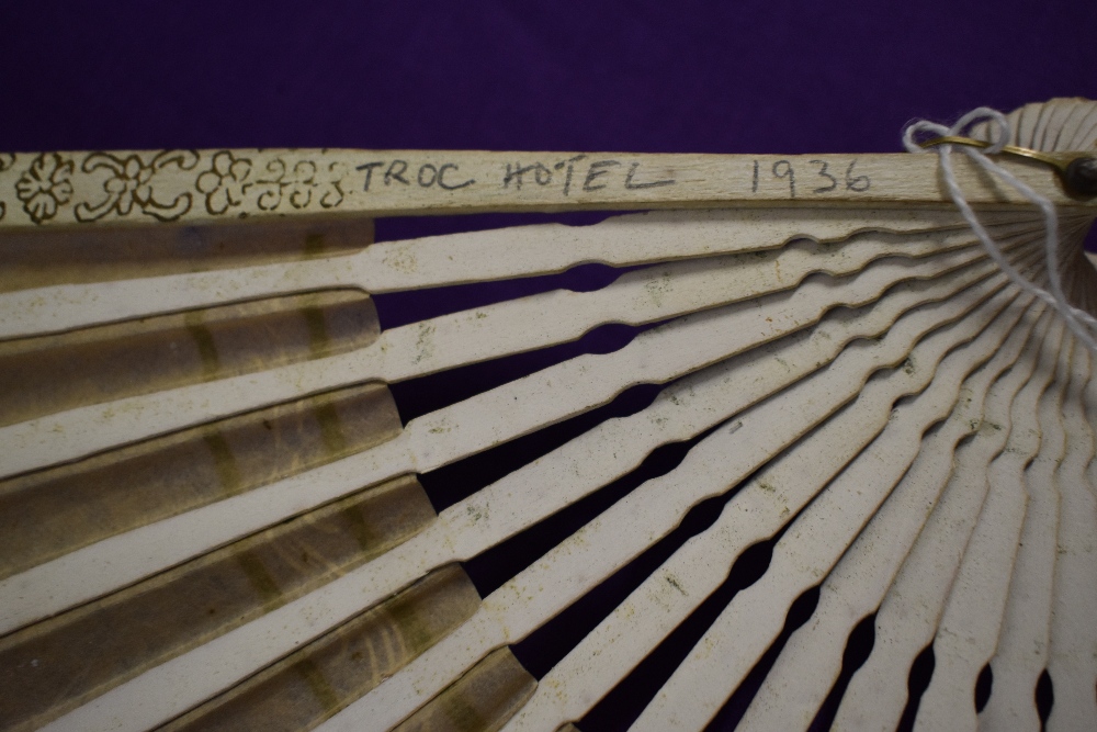 A vintage fan, having bone ribs, sold with another paper fan with hand painted decoration.