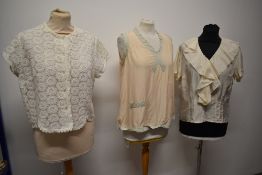 Three vintage blouses, including 1950s cream silk blouse with ruffles to front.