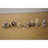 A group of seven Japanese resin carvings of deities and snake, the largest measures 5cm tall