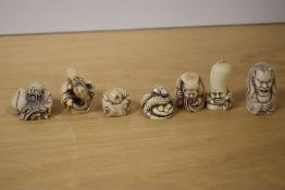 A group of seven Japanese resin carvings of deities and snake, the largest measures 5cm tall
