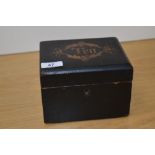 A 19th Century ebonised tea caddy, of rectangular form, with inlaid 'Tea' design to the lid,