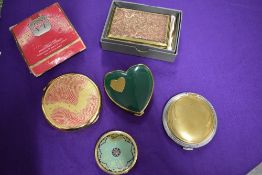 Five vintage compacts, including one gold plated L'aimant 75 year anniversary compact and a