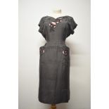 A wonderfully tailored American dress in grey and pink, having cut out detailing with raised