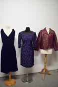 Two purple 1960s dresses and a cerise and gold jacket, having Art Deco styling.