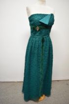 A 1950s / 1960s emerald green lace evening gown, having strapless bodice with velvet bow and