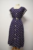 A 1940s/ 1950s cotton seersucker dress in navy blue with white dot print, having buttons to front