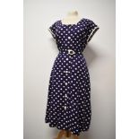 A 1940s/ 1950s cotton seersucker dress in navy blue with white dot print, having buttons to front