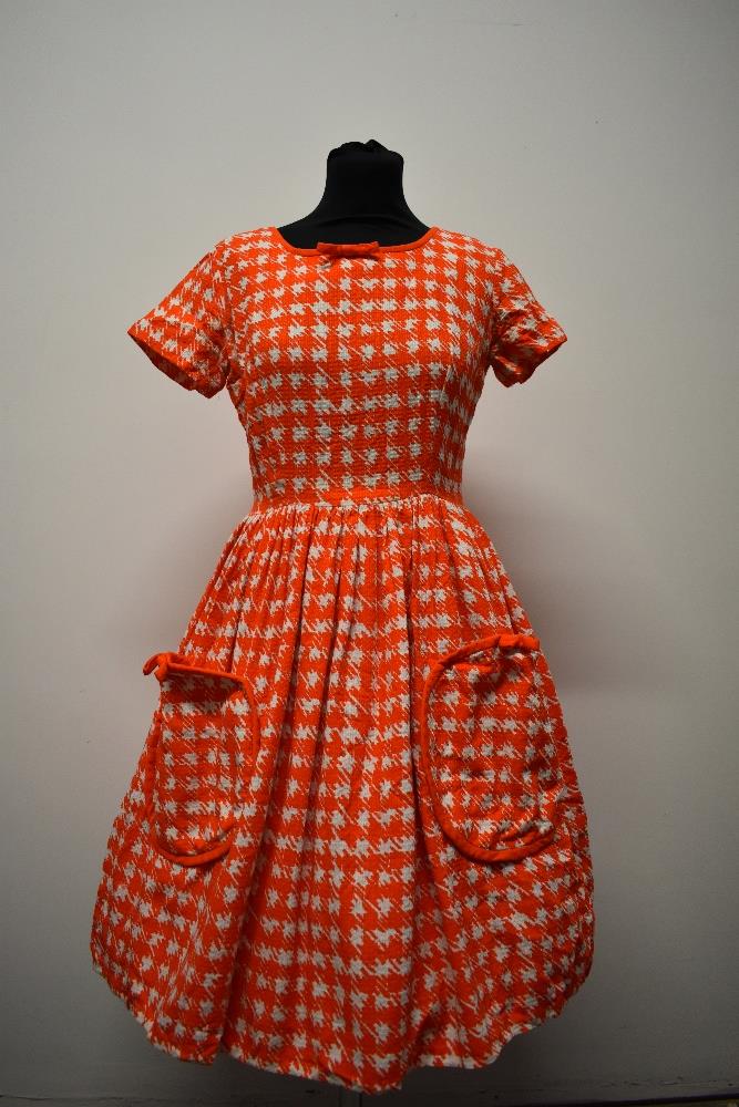 A textured medium weight cotton 1950s day dress, having orange and white dog tooth pattern, patch