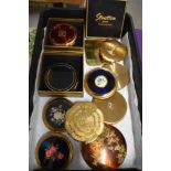 Eleven vintage compacts, including statue of Liberty compact and one having fuchsia decoration.