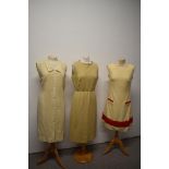 Three vintage 1960s dresses, one mid length metallic dress, a red and cream wool mini dress and a