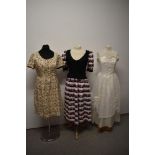 Three vintage dresses, including bright floral dress with contrasting black faux waistcoat.