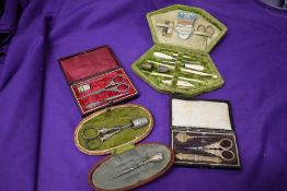Four antique sewing kits.