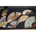 A collection of damaged fans, some particularly old ones among the collection, ribs and parts may be