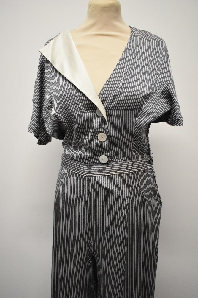 A silky striped vintage jump suit, having contrasting lapel and wide legs.