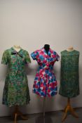 Three vintage dresses, one 1950s dress with vibrant pansy print having been historically