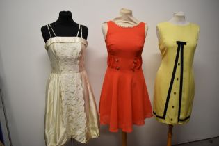 Three 1960s dresses, including lemon yellow linen dress with navy grosgrain bow detail and orange