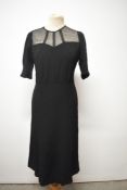 A 1940s black crepe de chine day dress, having tulle layer to bodice with bands to create a cage