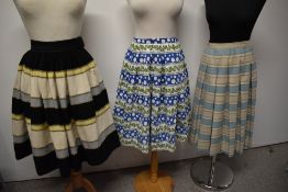 Three vintage 1950s to early 1960s skirts, one of striped wool and another of patterned cotton.