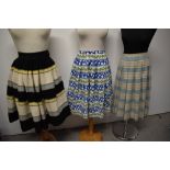 Three vintage 1950s to early 1960s skirts, one of striped wool and another of patterned cotton.