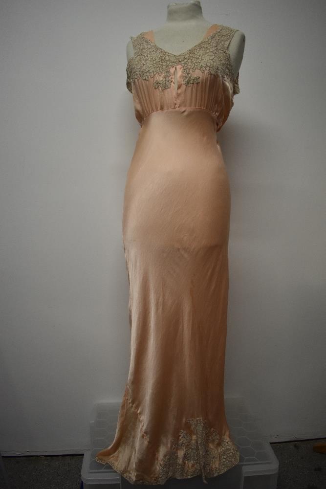 An Art Deco pale pink bias cut nightdress, having beautiful lace to bodice and hem, tie fastening to