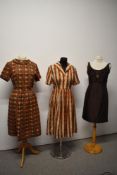 Two vintage 1950s day dresses, one of silk with pleated skirt and a 1960s dress with embellishment