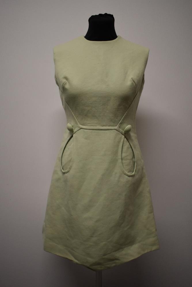 A mint green 1960s mini dress, with looped pockets and large button detail.