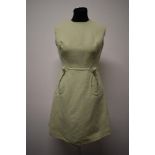 A mint green 1960s mini dress, with looped pockets and large button detail.