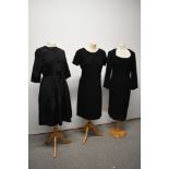 A 1950s black dress with pleated skirt and two 1960s wiggle dresses.