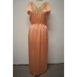 A 1920s pale pink silky 1920s nightdress, having adjustable ribbon fastening to waist, pretty lace