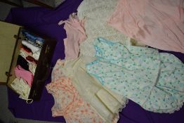 A large collection of vintage underwear and nightwear, including nylon slips, petticoats, knickers