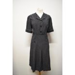 A dark navy blue medium weight cotton day dress with white polka dots, having piped detailing in
