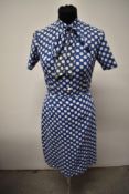 A 1950s blue blouse and skirt, with white dot pattern, having bow to neck of blouse and button