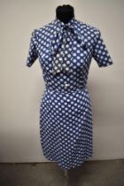 A 1950s blue blouse and skirt, with white dot pattern, having bow to neck of blouse and button