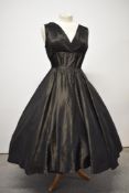 A 1950s full skirted black taffeta evening dress, having gold stripes to fabric, v neckline and side