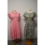 A late 1940s/ early 1950s pink medium weight cotton day dress, having buttons to front, peter pan