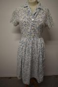 A 1950s abstract bubble pattern cotton day dress, having pleated skirt, buttons to front and side